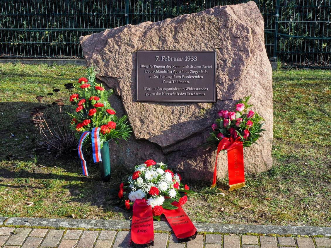 Blumengebinde mit Schleifen am Ernst-Thälmann-Gedenkstein in Ziegenhals