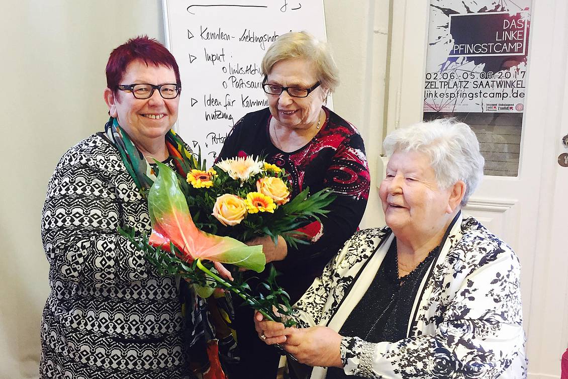 Bettina Fortunato und zwei weitere Frauen halten einen Blumenstrauß