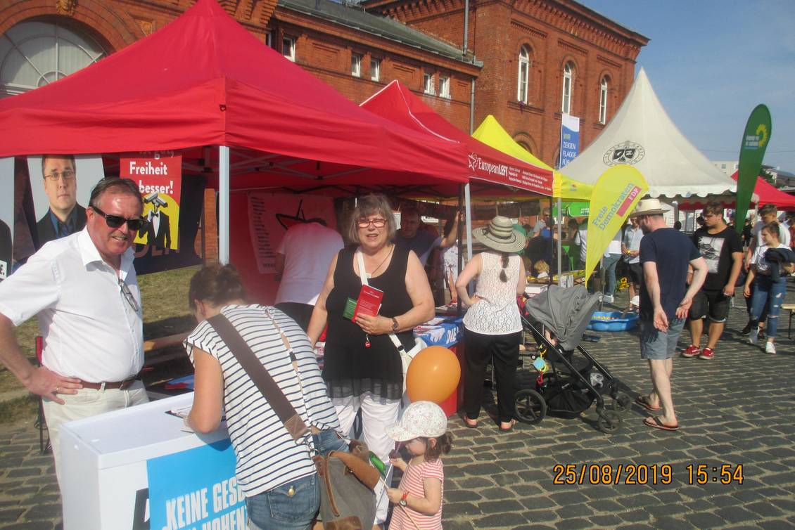 Stefan Ludwig und zwei Frauen stehen an einem Infostand