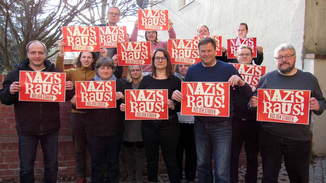 Fotoaktion des Landesvorstands mit Schildern, auf denen "Nazis raus aus den Stadien" steht