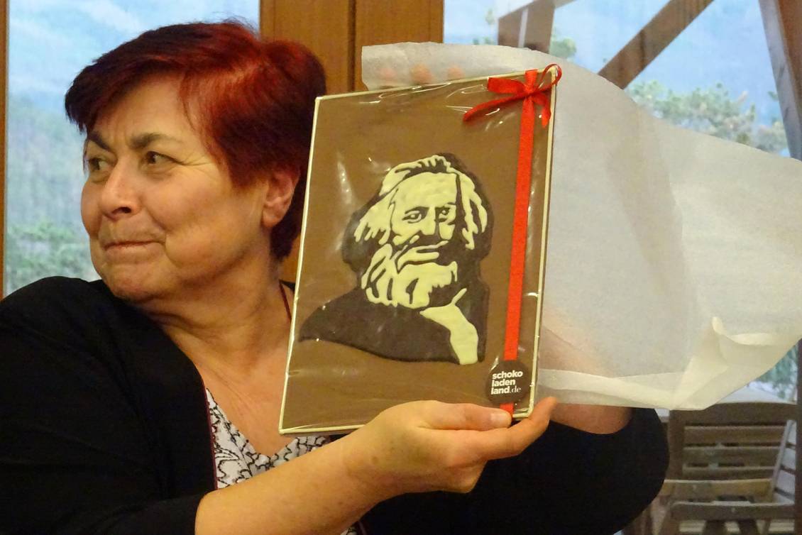 Eine Frau hält ein Bildnis von Karl Marx aus Schokolade in die Höhe