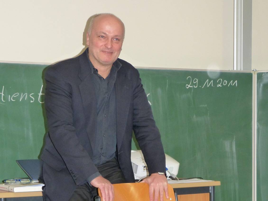 Volkmar Schöneburg steht vor einer Schultafel, die an einer Wand befestigt ist