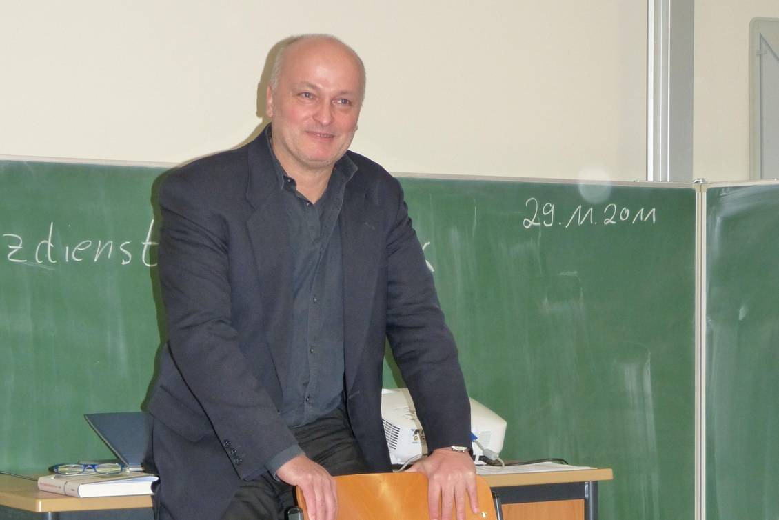 Volkmar Schöneburg steht vor einer Schultafel, die an einer Wand befestigt ist