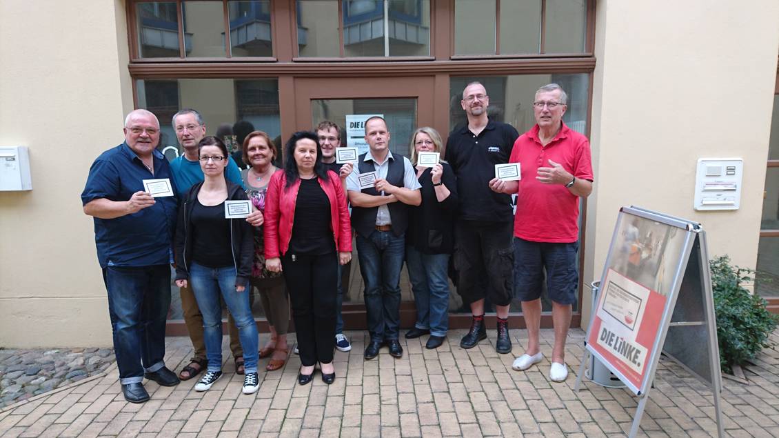 Mitglieder der LAG SozialGesund halten Postkarten in den Händen