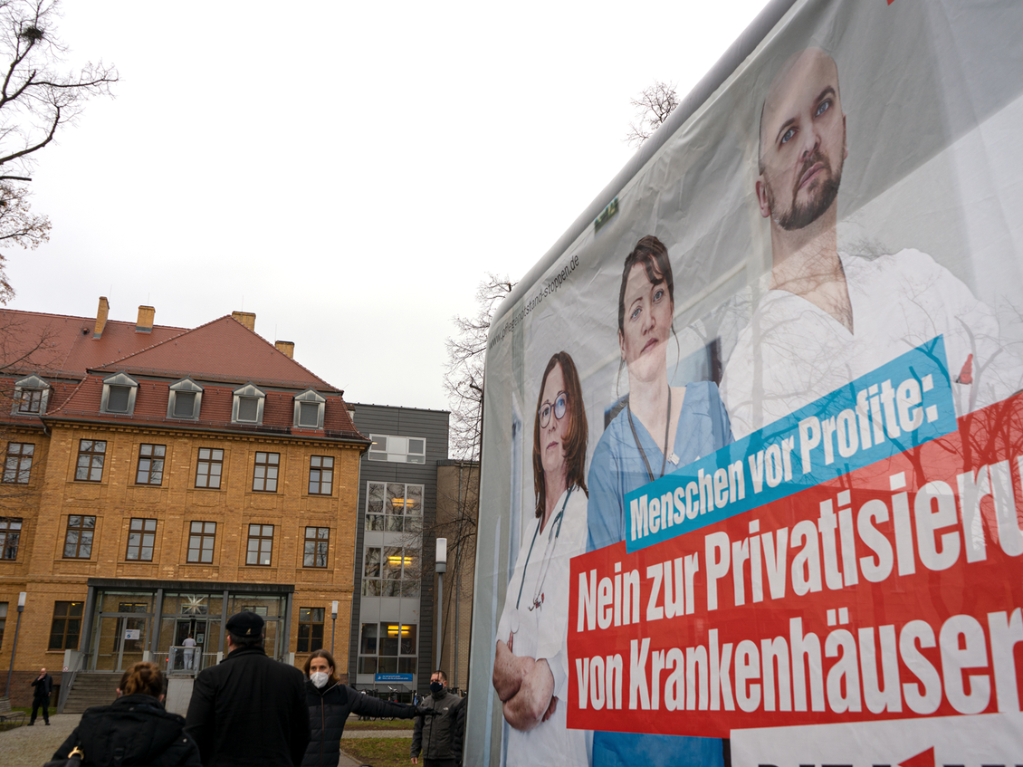 Gebäude des Klinkums in Senftenberg vor dem eine Großfläche steht mit dem Aufdruck "Menschen vor Profit: Nein zur Privatisierung von Krankenhäusern! DIE LINKE."