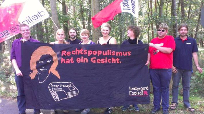 Gruppenfoto mit Fahnen von Linksjugend ['solid] und einem Transparent mit der Aufschrift: "Rechtspopulismus hat ein Gesicht"