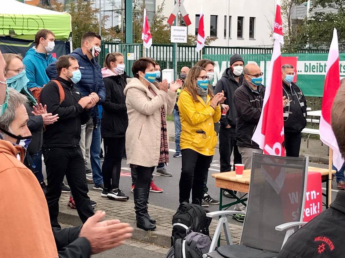Anja Mayer und Katharina Slanina in einer Versammlung von Streikenden, die alle einen Mund-Nase-Schutz tragen