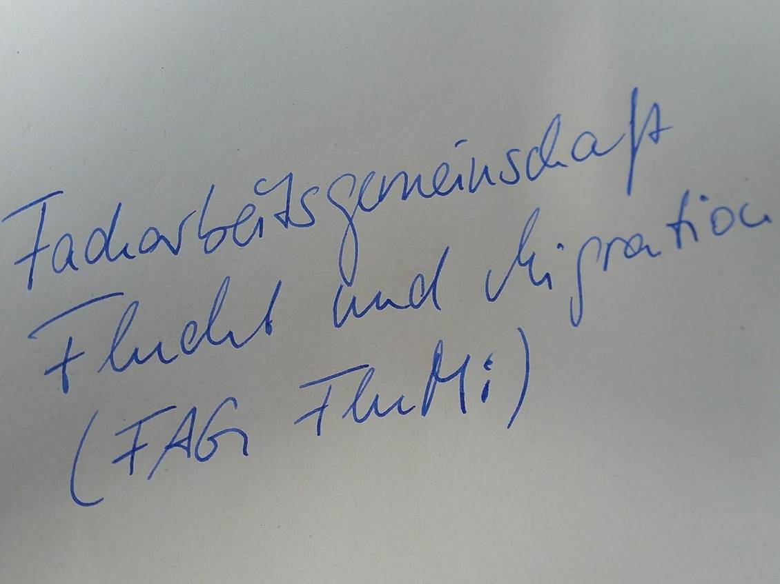 Zettel auf dem Facharbeitsgemeinschaft Flucht und Migration (FAG FluMi) steht