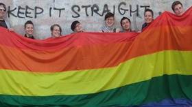Mitglieder der LAG Queer mit einer überdimensionalen Regenbogen-Flagge