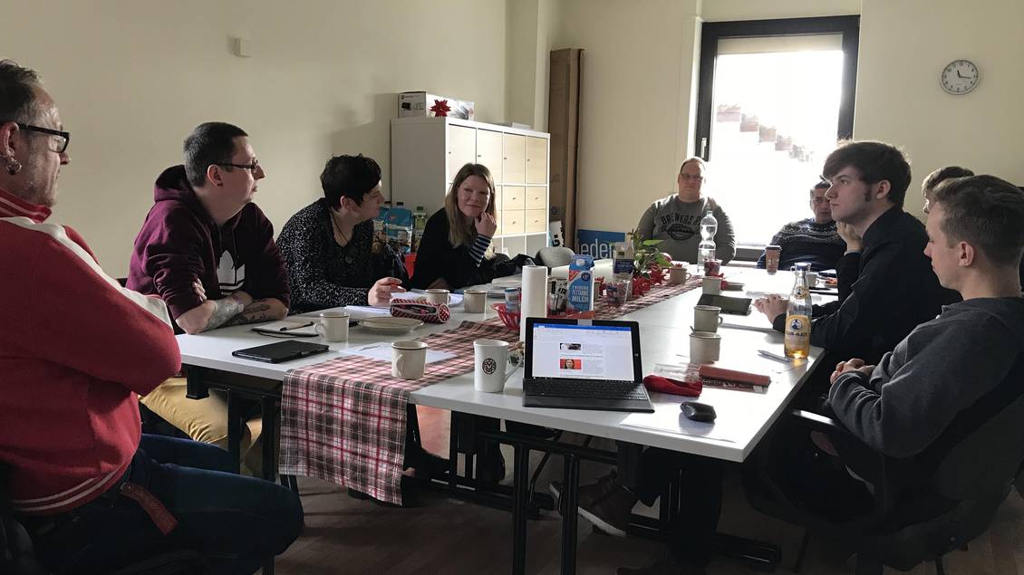 Carsten Schatz, Doris Achelwilm und Diana Bader sitzen mit mehreren Personen an einem Tisch