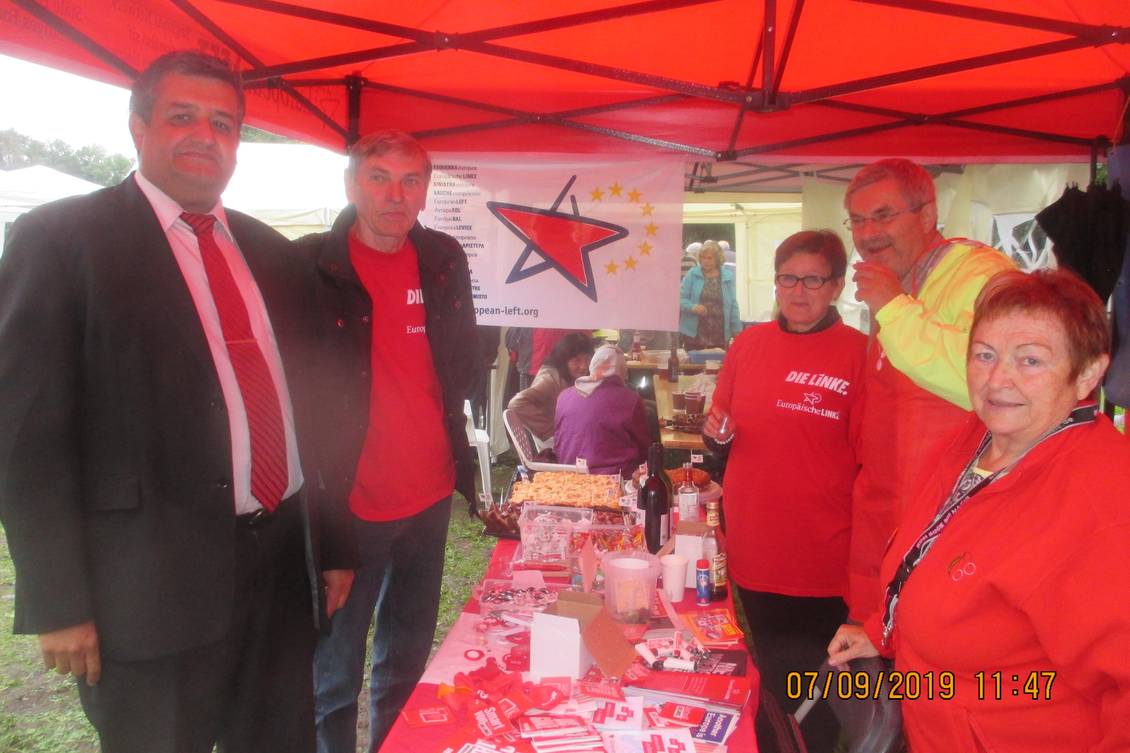 Roter Pavillon und Infotisch mit Material, um den mehrere Personen stehen