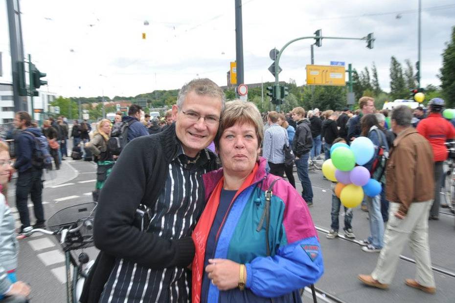 Harald Petzold legt den Arm um eine Frau, beide schauen in die Kamera