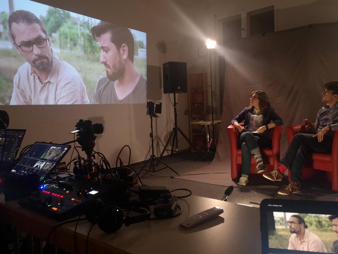Filmset mit Scheinwerfern, Kamera und dem Film, der per Beamer an die Wand geworfen wird
