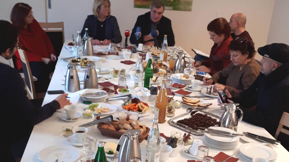 Ralf Christoffers, Kathrin Dannenberg und weitere Personen sitzen an einem gedeckten Tisch