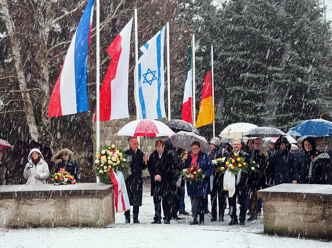 Teilnehmer*innen mit Regenschirmen und Blumengestecken