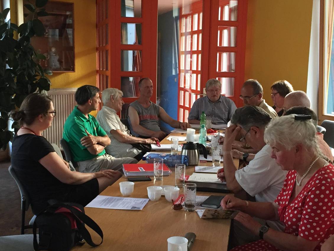 Anja Mayer und eine Gruppe Menschen sitzen an einem langen Tisch