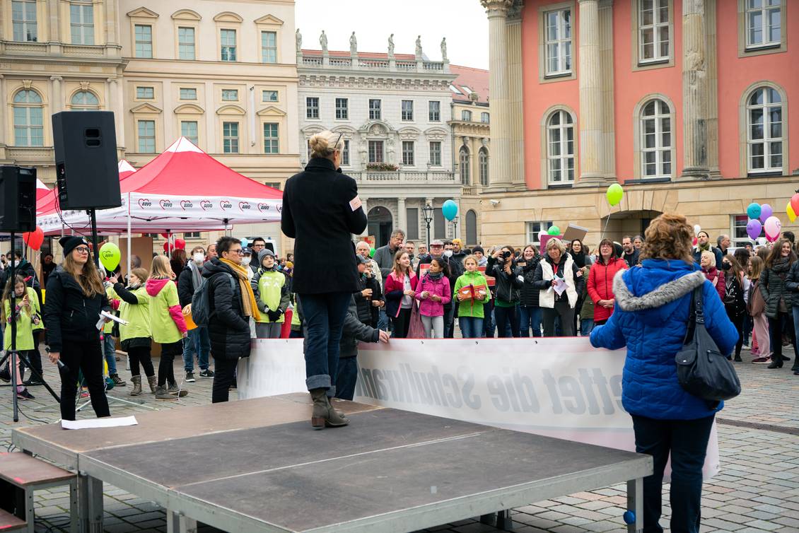 Angela Schweers steht auf einem Podest vor den Teilnehmern der Kundgebung
