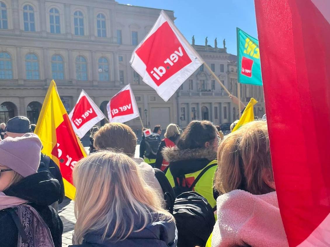 Kundgebung auf dem Alten Markt in Potsdam mit Fahnen, auf denen das ver.di-Logo zu sehen ist