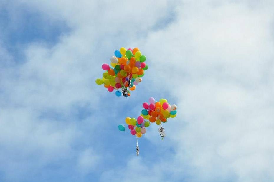 Bunte Luftballons steigen in den blauen Himmel