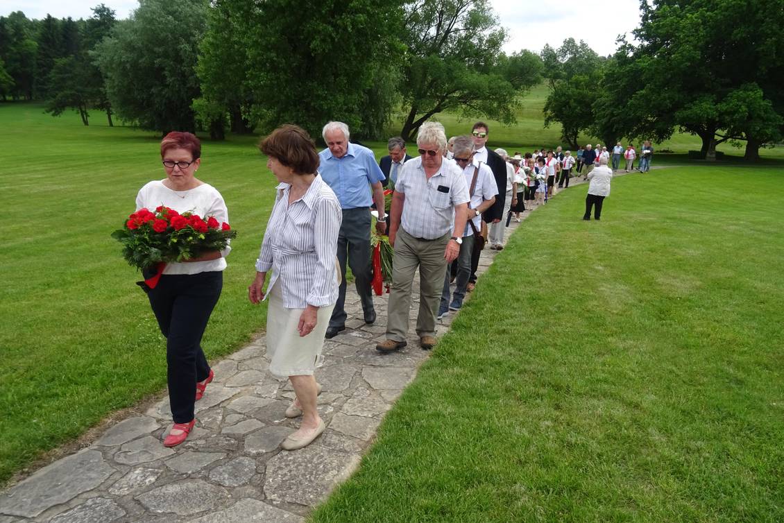 Teilnehmer der Gedenkveranstaltung in Lidice, Monika Schömmel trägt ein rotes Blumengebinde