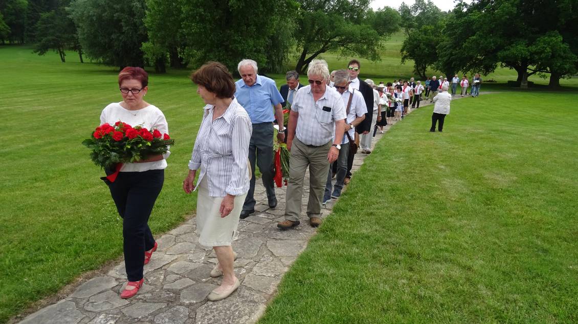 Teilnehmer der Gedenkveranstaltung in Lidice, Monika Schömmel trägt ein rotes Blumengebinde