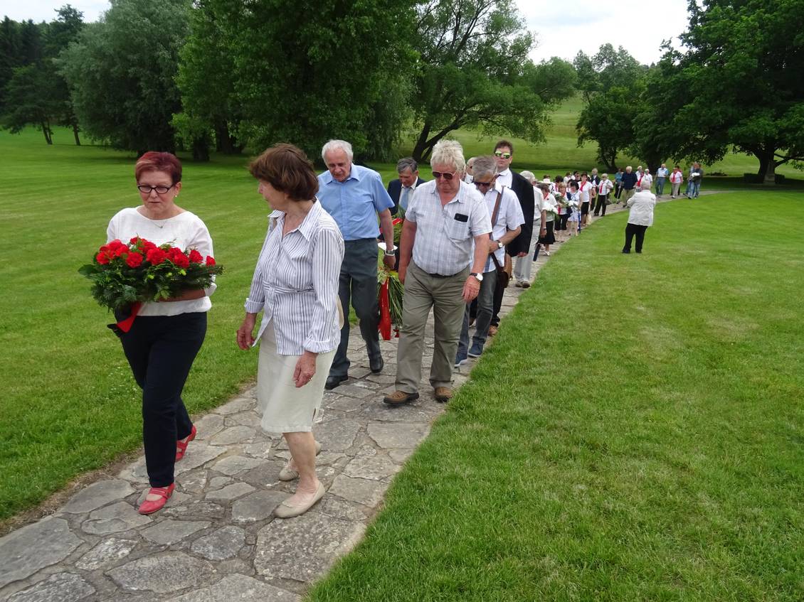 Teilnehmer der Gedenkveranstaltung in Lidice, Monika Schömmel trägt ein rotes Blumengebinde
