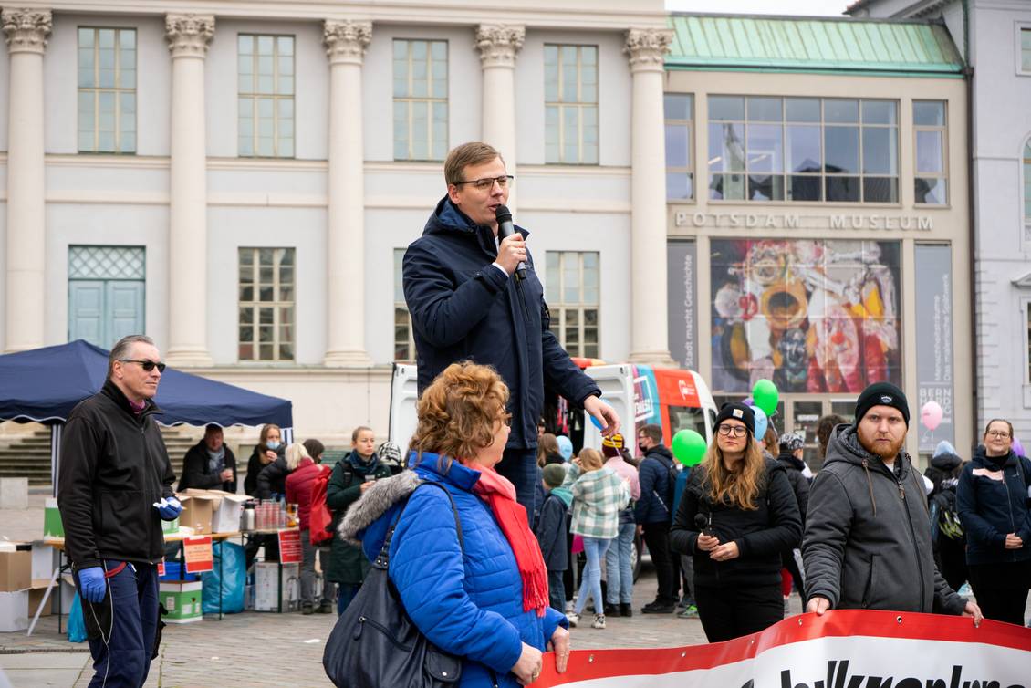 Sebastian Walter steht mit einem Mikrofon in den Händen auf einem Podest