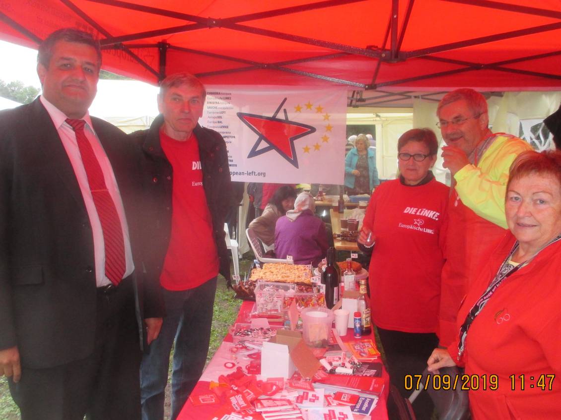 Roter Pavillon und Infotisch mit Material, um den mehrere Personen stehen