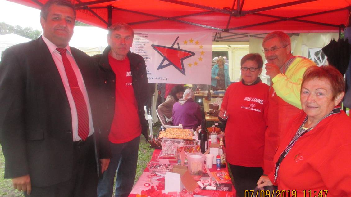 Roter Pavillon und Infotisch mit Material, um den mehrere Personen stehen