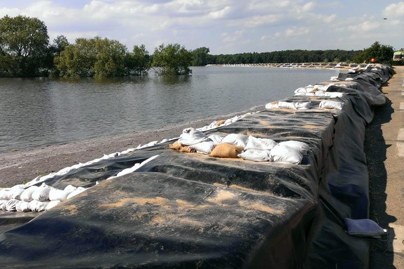 Damm aus Sandsäcken am Ufer eines Flusses