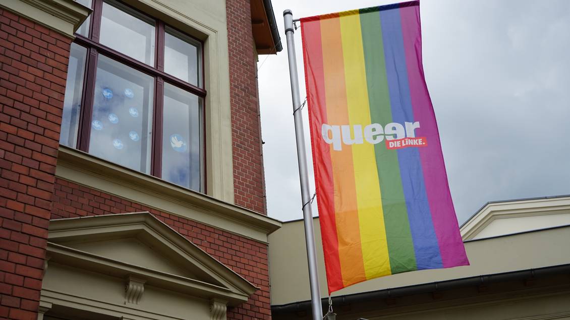 Eine Flagge in regenbogenfarben mit dem Aufdruck "queer - DIELINKE." weh am Fahnenmast vor dem Lothar-Bisky-Haus