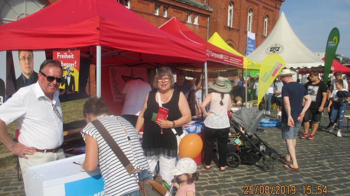 Stefan Ludwig und zwei Frauen stehen an einem Infostand