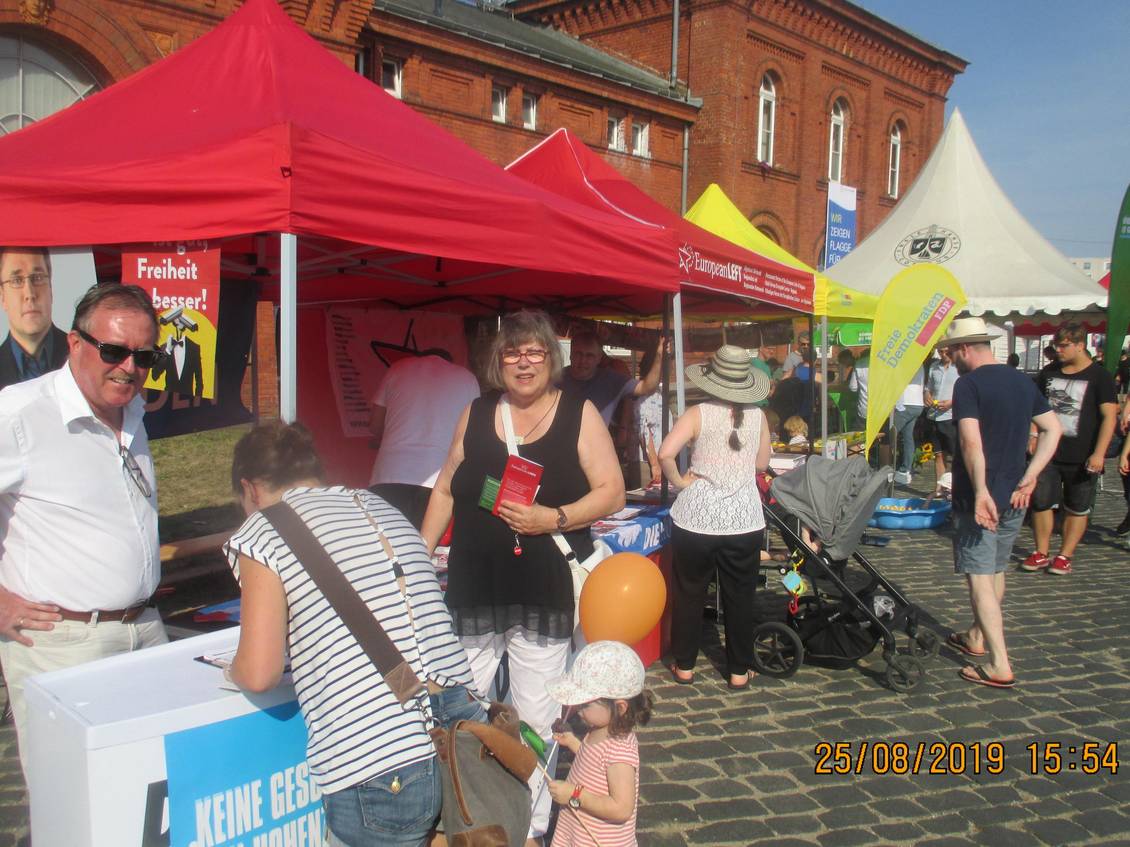 Stefan Ludwig und zwei Frauen stehen an einem Infostand
