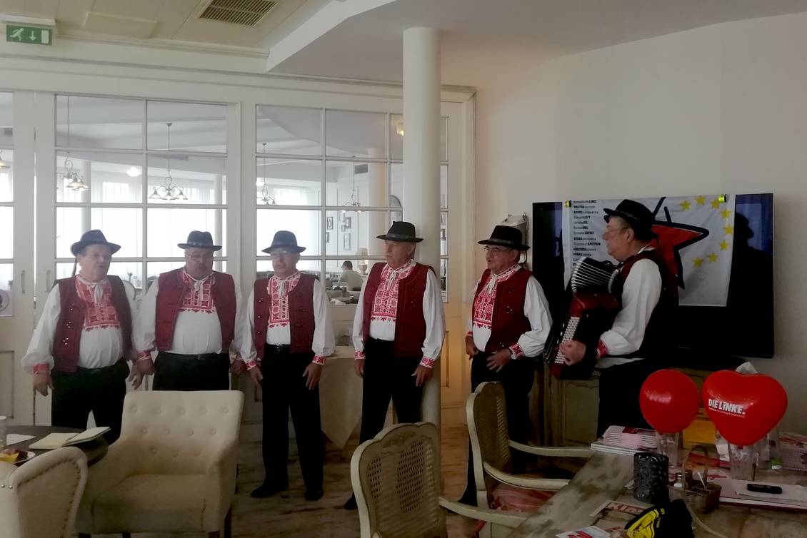 Eine in Tracht gekleidete Sängergruppe mit einem Akkordeonspieler