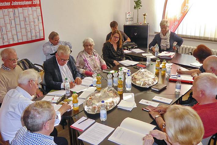 Anja Mayer, Anita Tack und weitere Menschen sitzen um einen Besprechungstisch